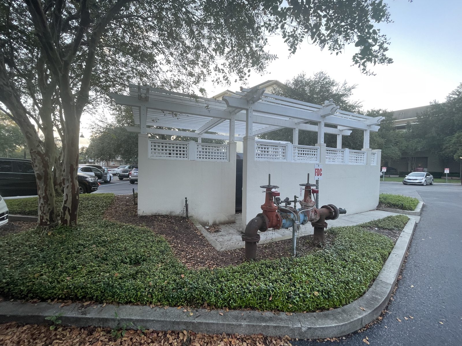 White pergola-topped lattice enclosure